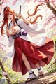 A woman with long red hair holds a sword, dressed in traditional attire, standing amidst cherry blossoms.