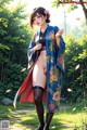 A woman in a blue kimono is posing for a picture.