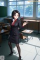 A woman in a business suit standing in front of a classroom.