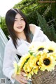 A woman holding a basket of sunflowers in her hands.