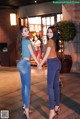 Two young women holding hands in front of a restaurant.