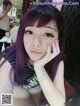 A woman with purple hair sitting at a table.