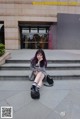 A woman sitting on the steps of a building.