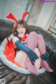 A woman in a bunny costume sitting on a couch.