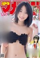 A woman in a black bikini posing for a magazine cover.