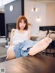 A woman sitting on top of a wooden table with her feet up.