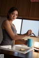 A woman is pouring water into a blue cup.