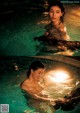 A woman in a swimming pool with a light shining on her face.