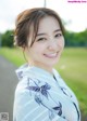 A woman in a kimono smiles at the camera.