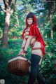 A woman dressed as a red riding hood holding a basket.