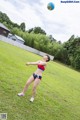 A woman in a bikini playing volleyball in a field.