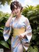 A woman in a blue and yellow kimono posing for a picture.