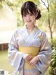 A woman in a blue and yellow kimono posing for a picture.